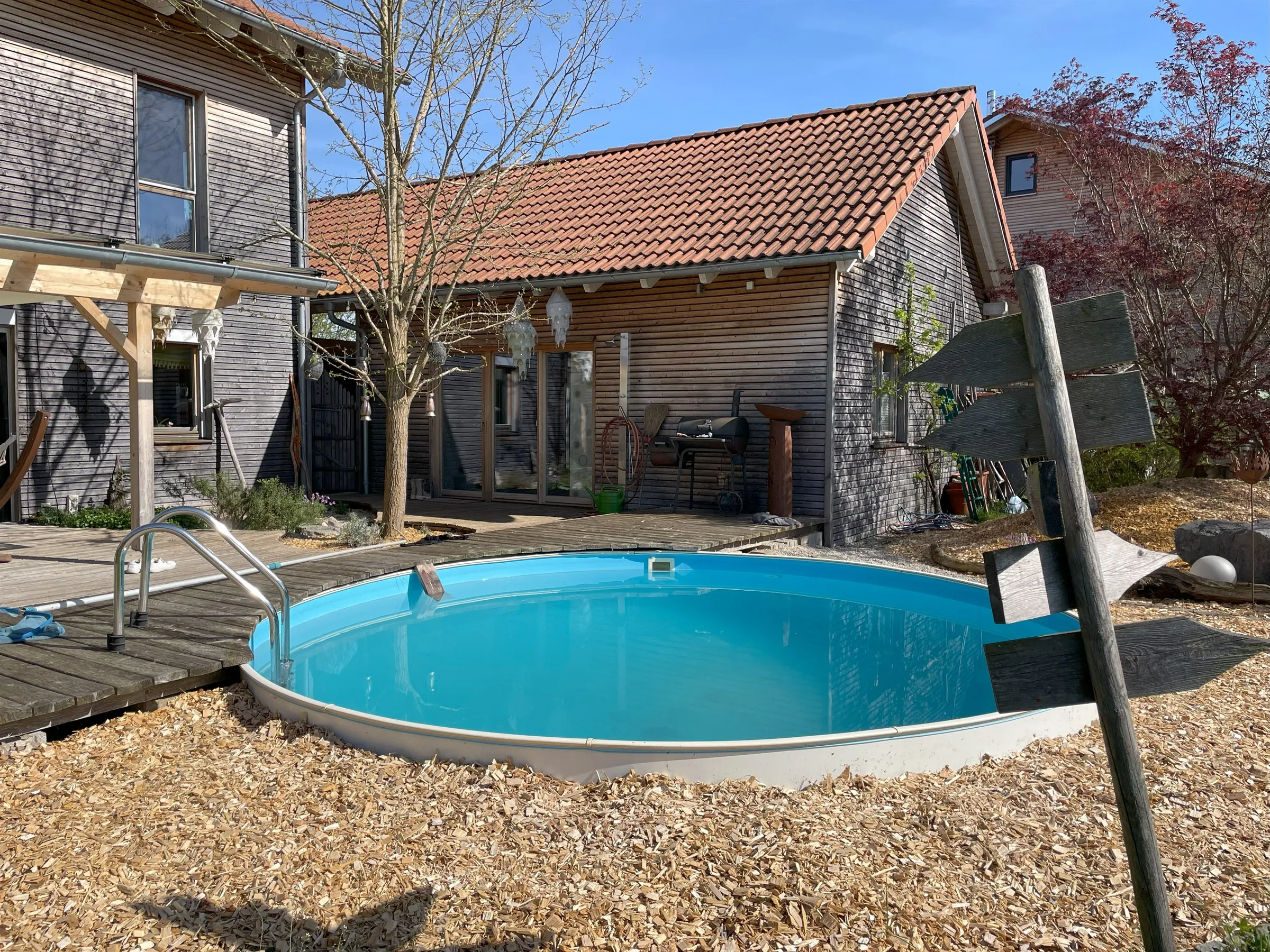 Pool mit Blick auf das Nebengebäude mit Solarthermie-Kollektoren