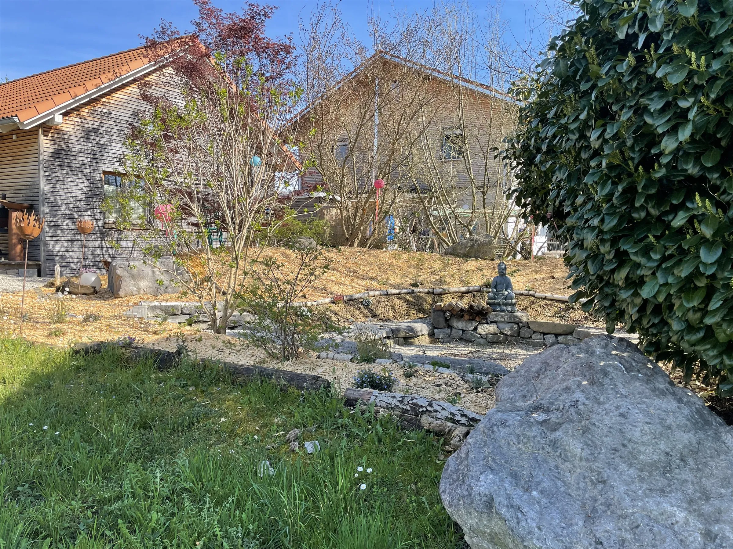 Angelegter Gartenbereich mit Natursteinen und Bepflanzung